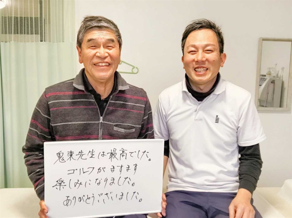 「鬼束先生は最高でした、ゴルフが楽しみになちました、ありがとうございます」と書かれたホワイトボードを持つ70代の男性患者様と、都城市はる整体院 院長 鬼束清正との写真